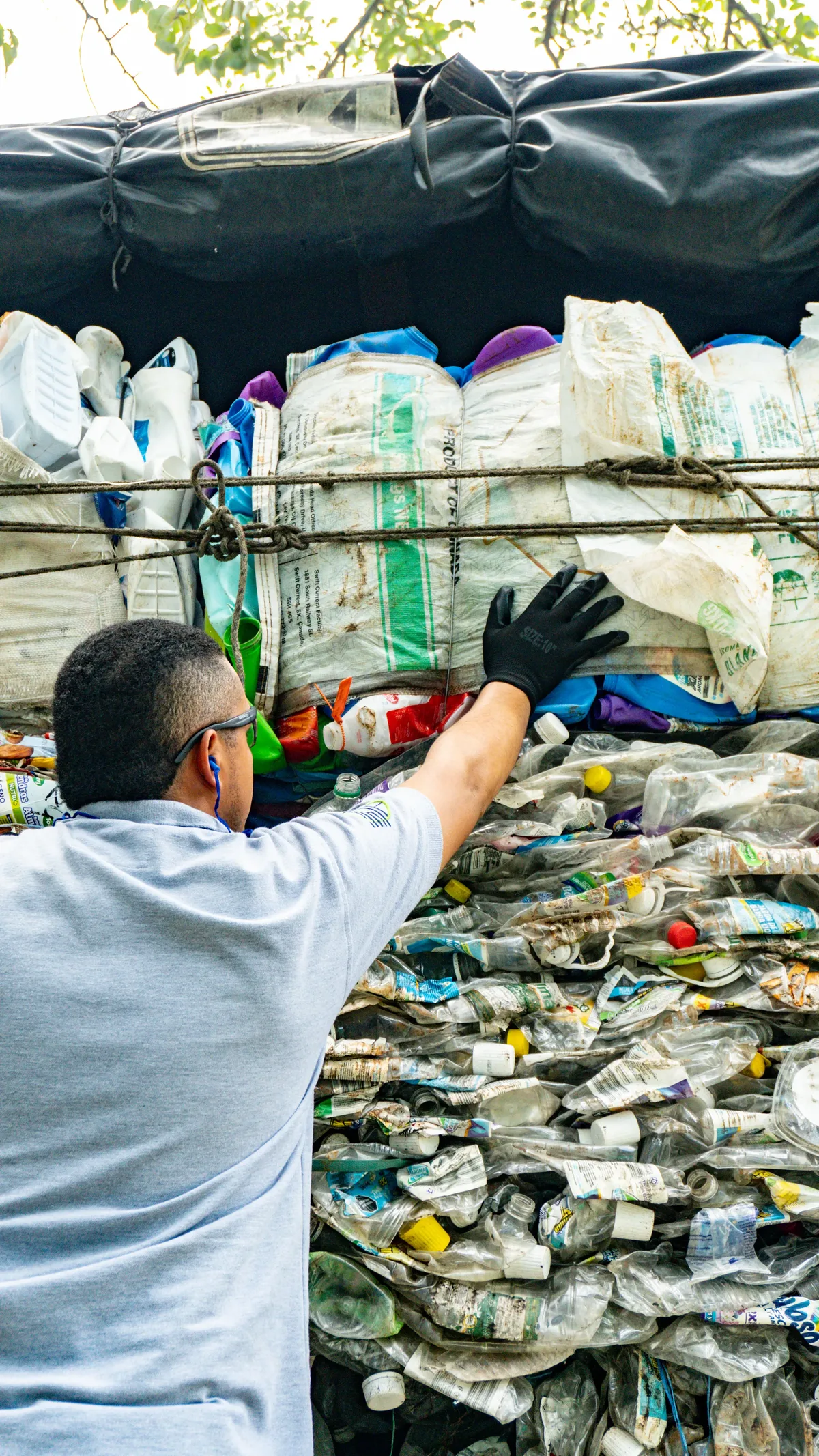 Operario de G&S asegurando pacas de botellas PET recuperadas sobre un camión